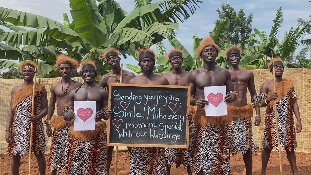 African men dancing with a birthday greeting sign